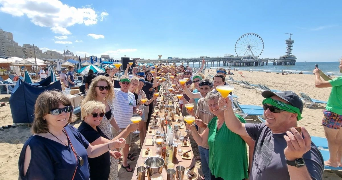 3. Een groep lachende mensen die tijdens een bedrijfsuitje hun cocktails proosten